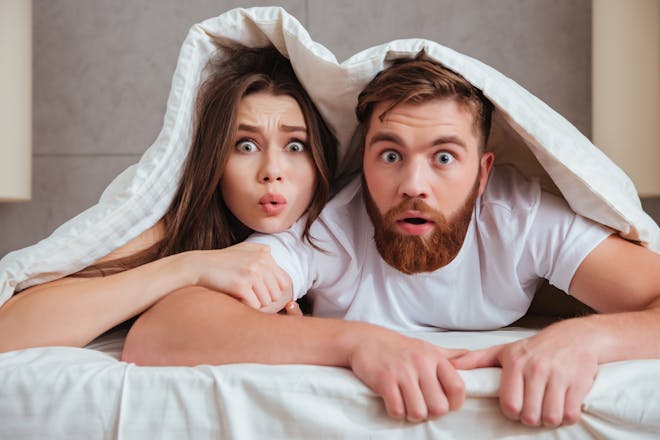 shocked couple under a duvet cover