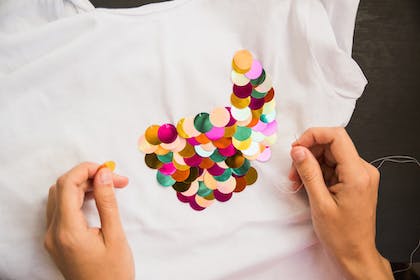 Sequins being sewn onto a t-shirt