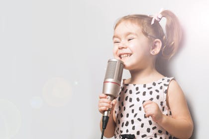 Little girl singing into a microphone